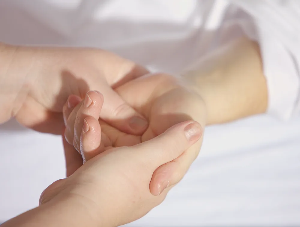 Therapist performing hands-on manual hand therapy treatment